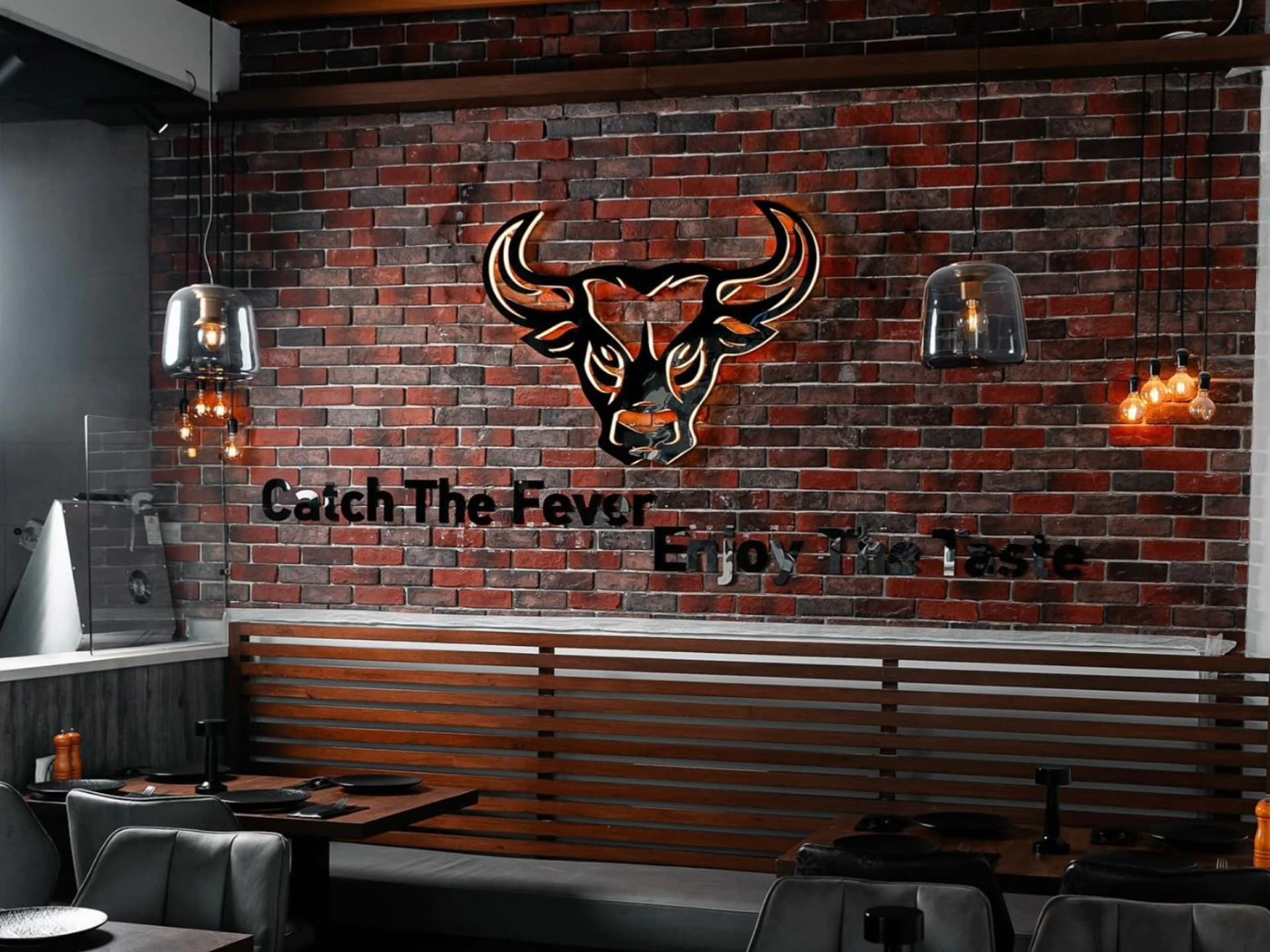 Modern steakhouse interior with bull logo wall decor