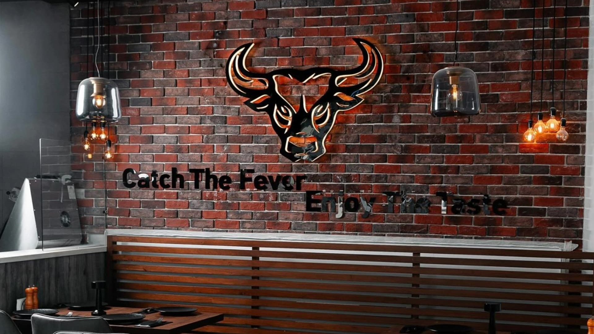 Modern steakhouse interior with bull logo wall decor